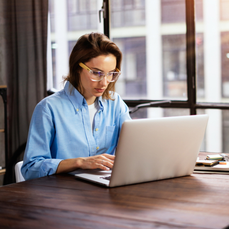 A woman typing on a laptop