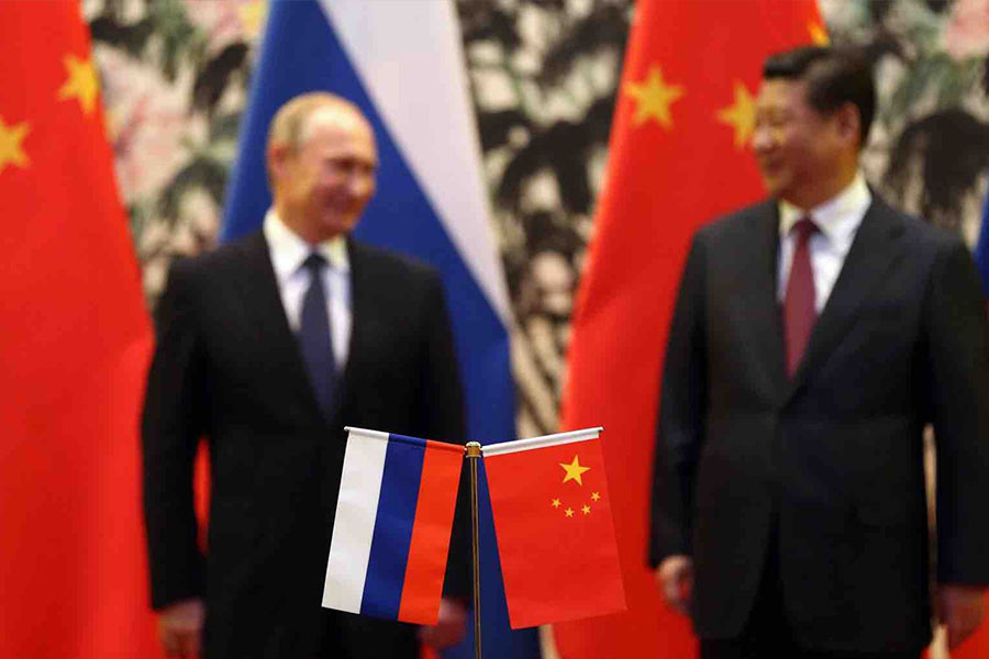 The Russian and Chinese national flags are seen on the table as Russia's President Vladimir Putin and his China's President Xi Jinping stand during a signing ceremony at the Diaoyutai State Guesthouse in Beijing on Nov. 9, 2014. Accessed from Foreign Poli