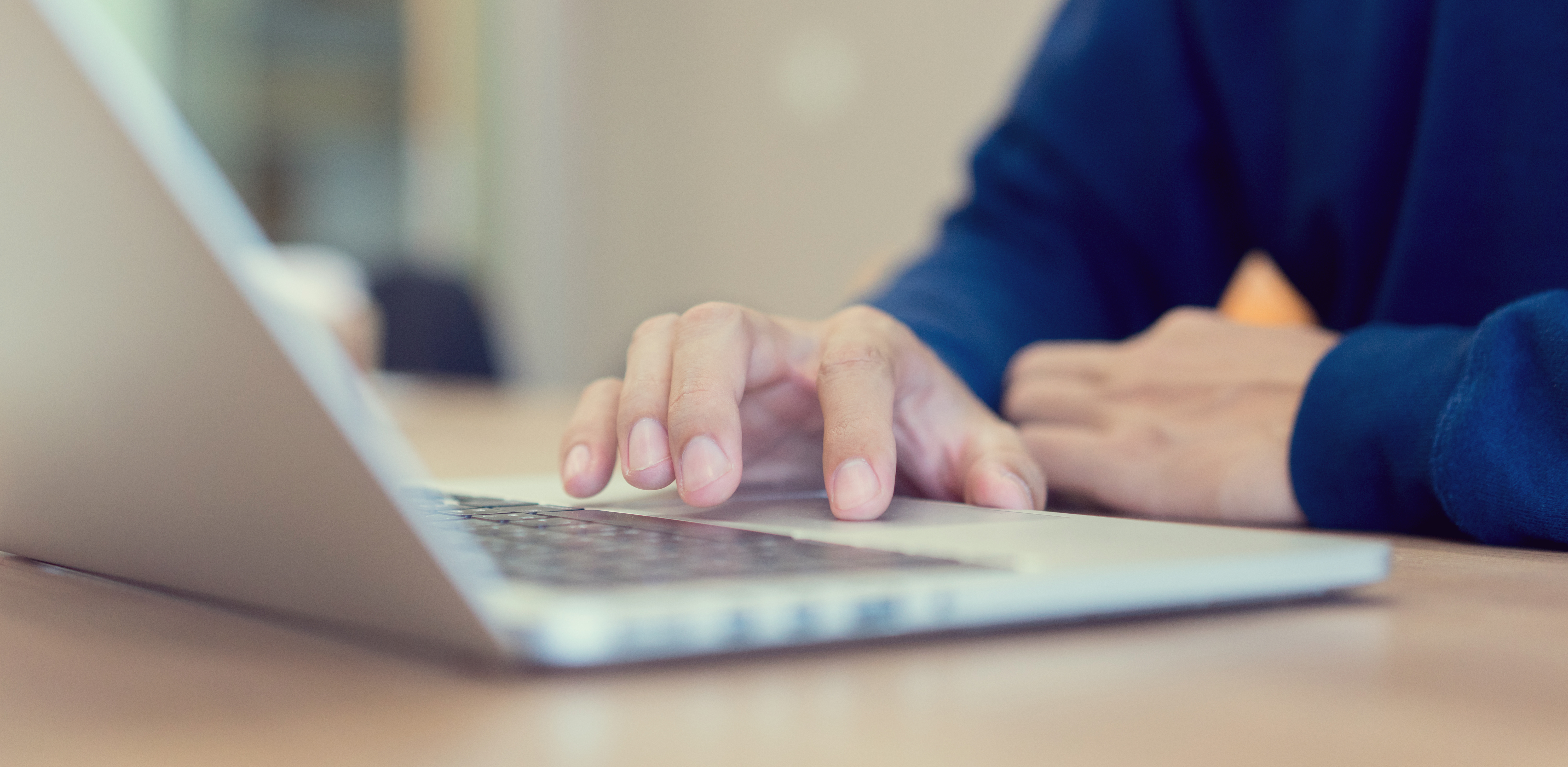 A man typing on a laptop 